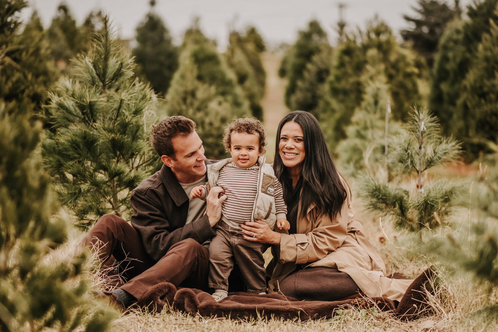 Olivia with her husband and son at a Christmas tree farm