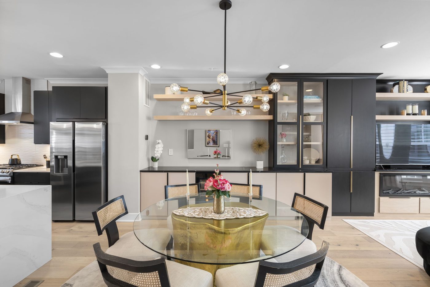 Dining area with round glass table and sculptural chandelier