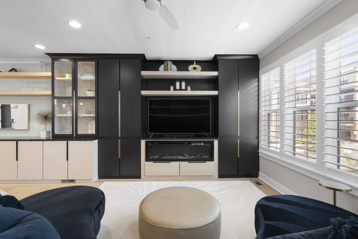 Living room with built-in cabinetry and plantation shutters