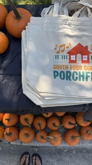 Porch Fest tote bags and pumpkins at the giveaway table